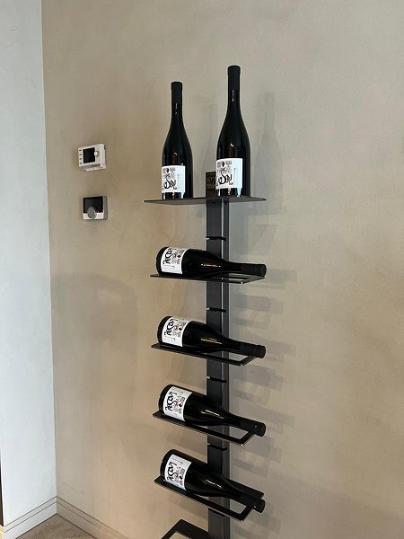 Étagère à vin modulable noire fixée au mur avec six bouteilles de vin exposées