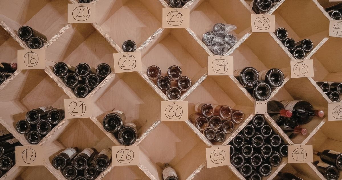 Casier à vin traditionnel en bois avec bouteilles rangées couchées et numérotées par emplacement
