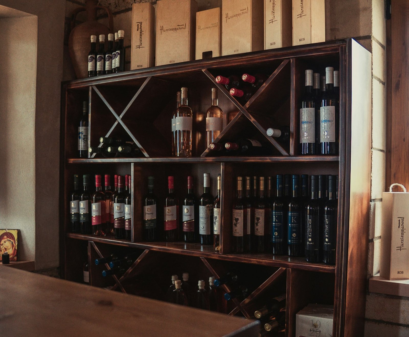 Bouteilles de vin couchées sur étagère murale, étiquettes face visible pour identification immédiate sans manipuler les bouteilles