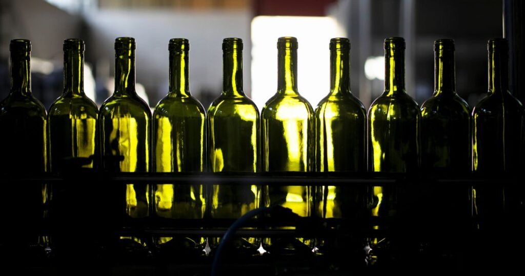 Green wine bottles lined up before filling