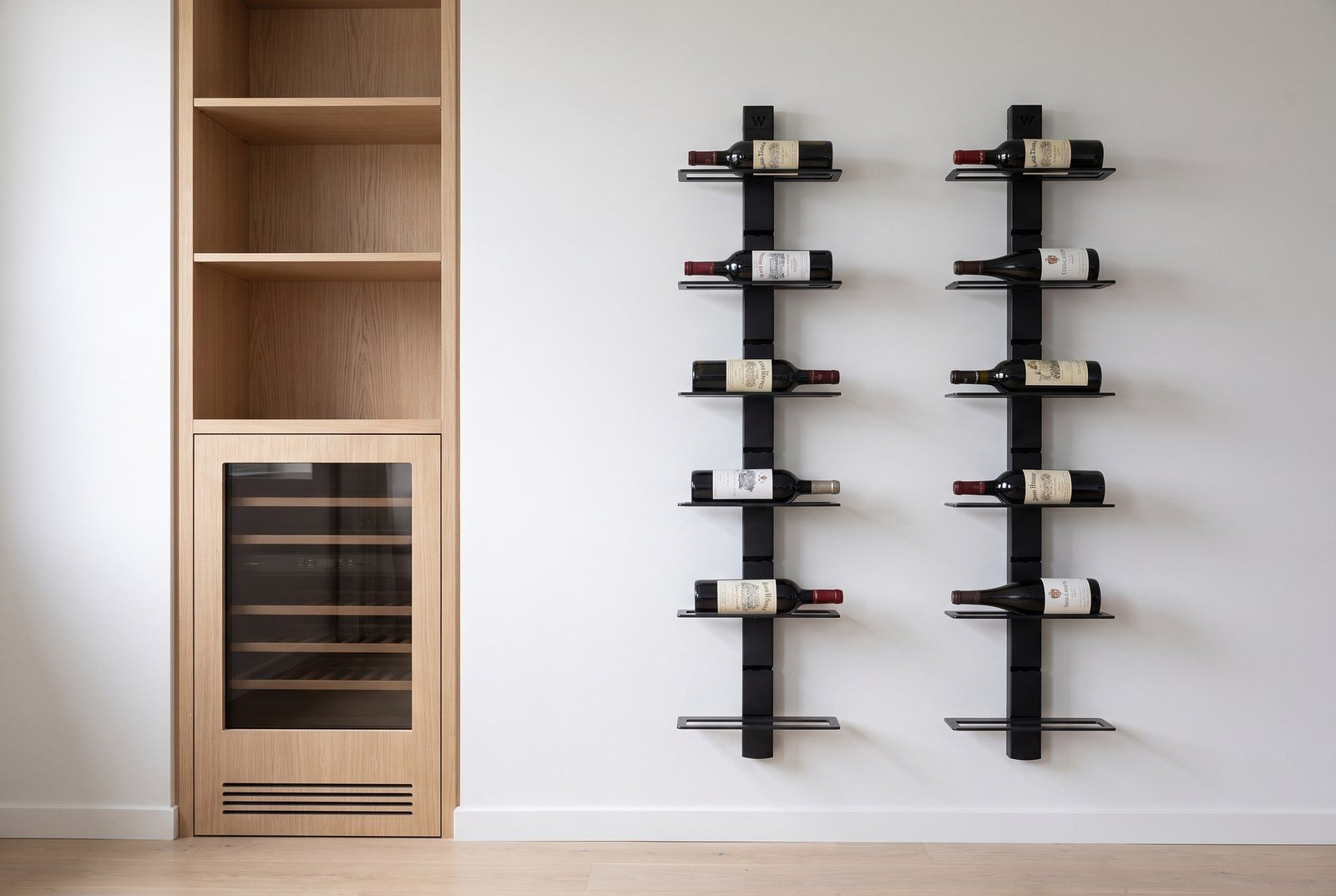 Cave à vin encastrée dans une bibliothèque à côté d'un mur de bouteilles couchées étiquettes visibles