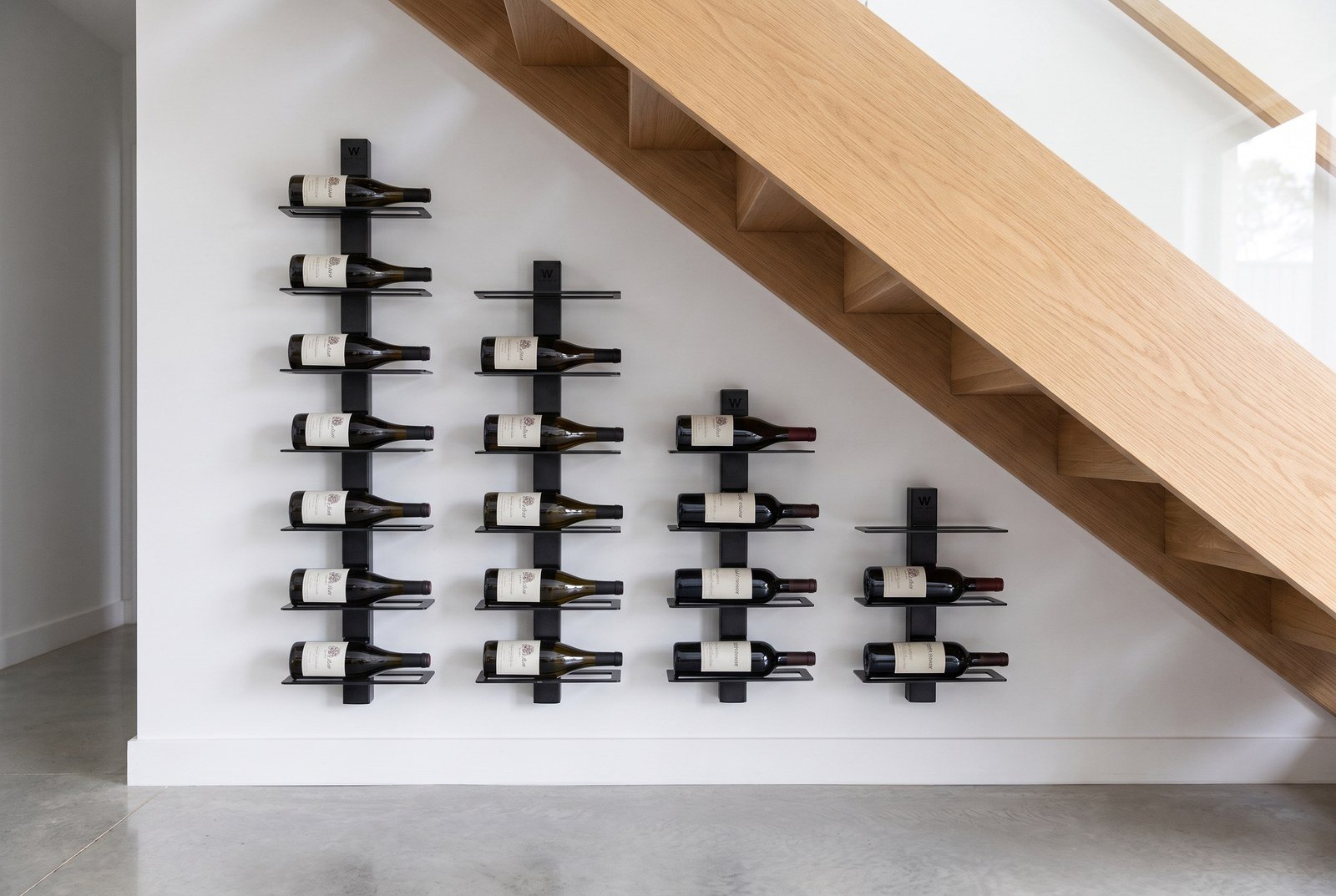 Four modules placed side by side under a staircase, with the number of shelves decreasing to follow the slope